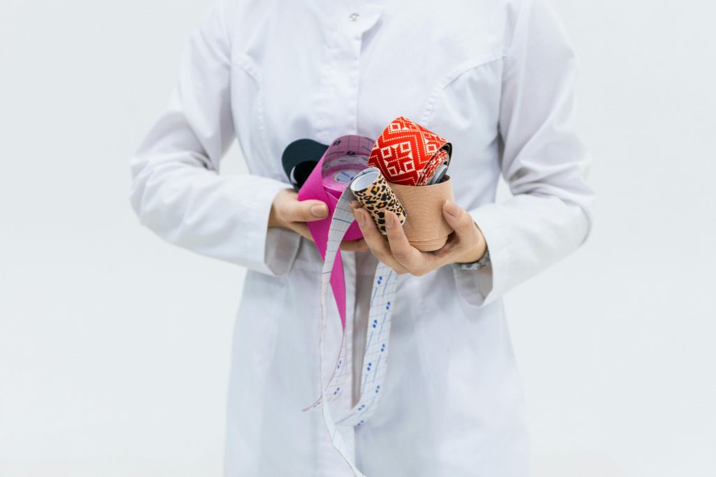 Healthcare professional holding colorful kinesiology tape for medical therapy and treatment.