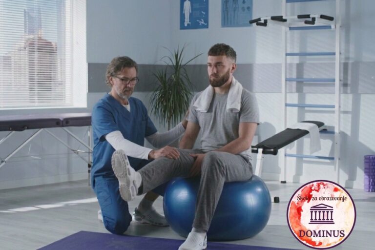 Fizioterapeut u plavoj uniformi pomaže pacijentu koji sjedi na velikoj plavoj lopti tokom vježbi ravnoteže u rehabilitacijskoj ordinaciji.
