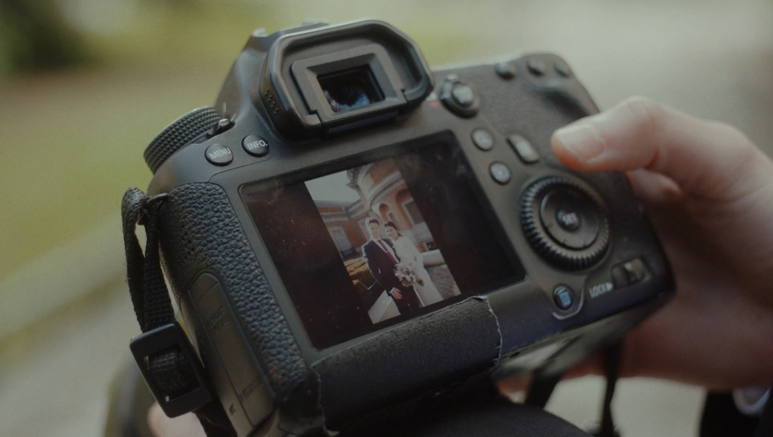 Fotograf provjerava snimljenu fotografiju mladenaca na zaslonu fotoaparata