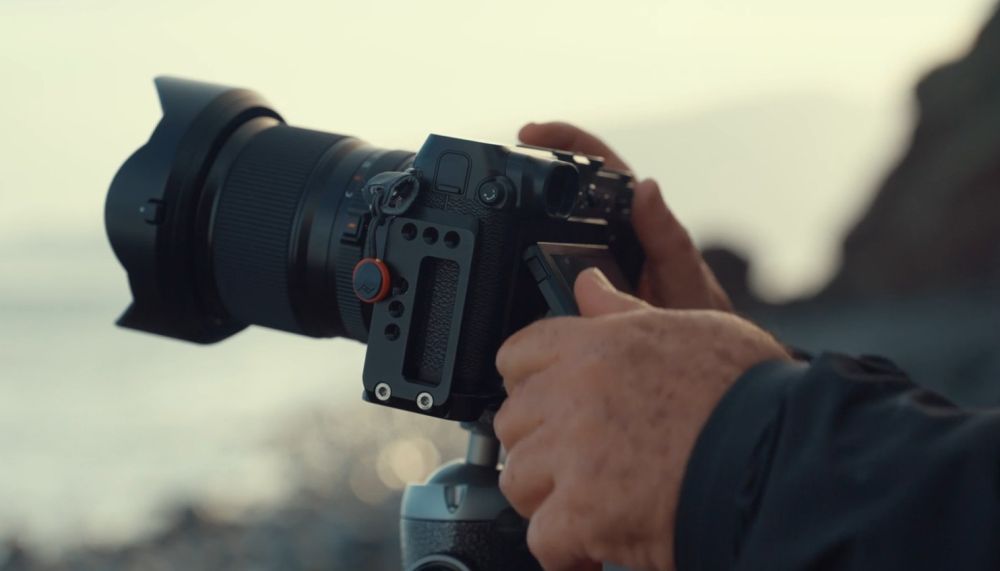 Fotograf podešava profesionalni fotoaparat sa zoom objektivom prije snimanja