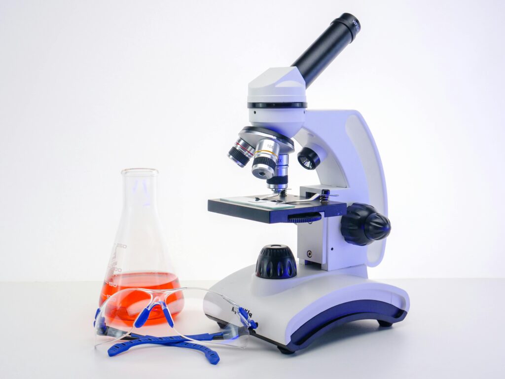 Mikroskop, laboratorijska tikvica i zaštitne naočale kao dio opreme u obrazovanju sanitarnog tehničara.