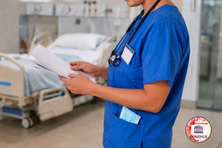 Medicinska sestra u plavoj uniformi drži medicinsku dokumentaciju u rukama, dok se u pozadini vidi bolnički krevet u bolesničkoj sobi