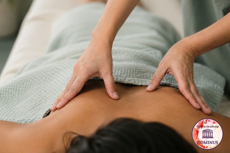 Terapeut izvodi deep tissue masažu leđa klijenta u mirnom spa ambijentu, uz prirodne tonove i opuštajuću atmosferu