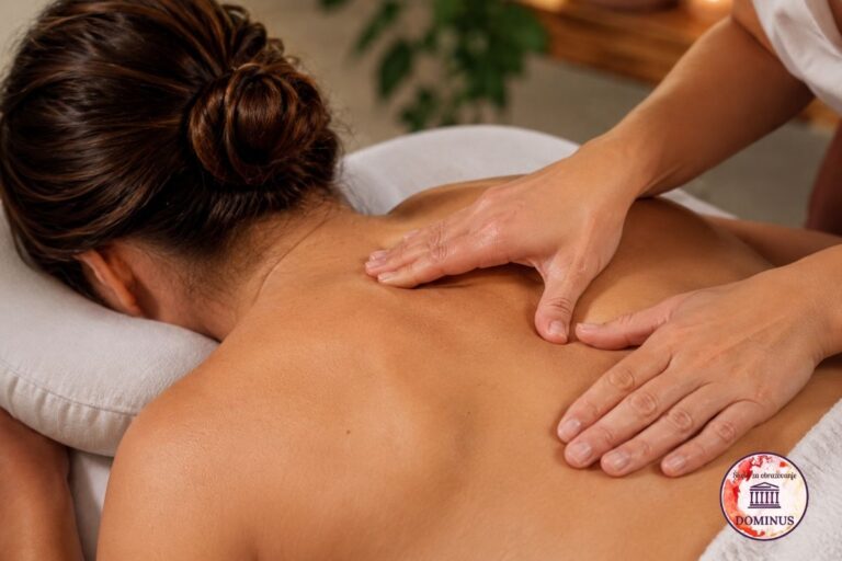 Žena prima vezivno-tkivnu masažu leđa u opuštajućem spa ambijentu, dok terapeutkinja primjenjuje ciljane pritiske rukama duž gornjeg dijela leđa