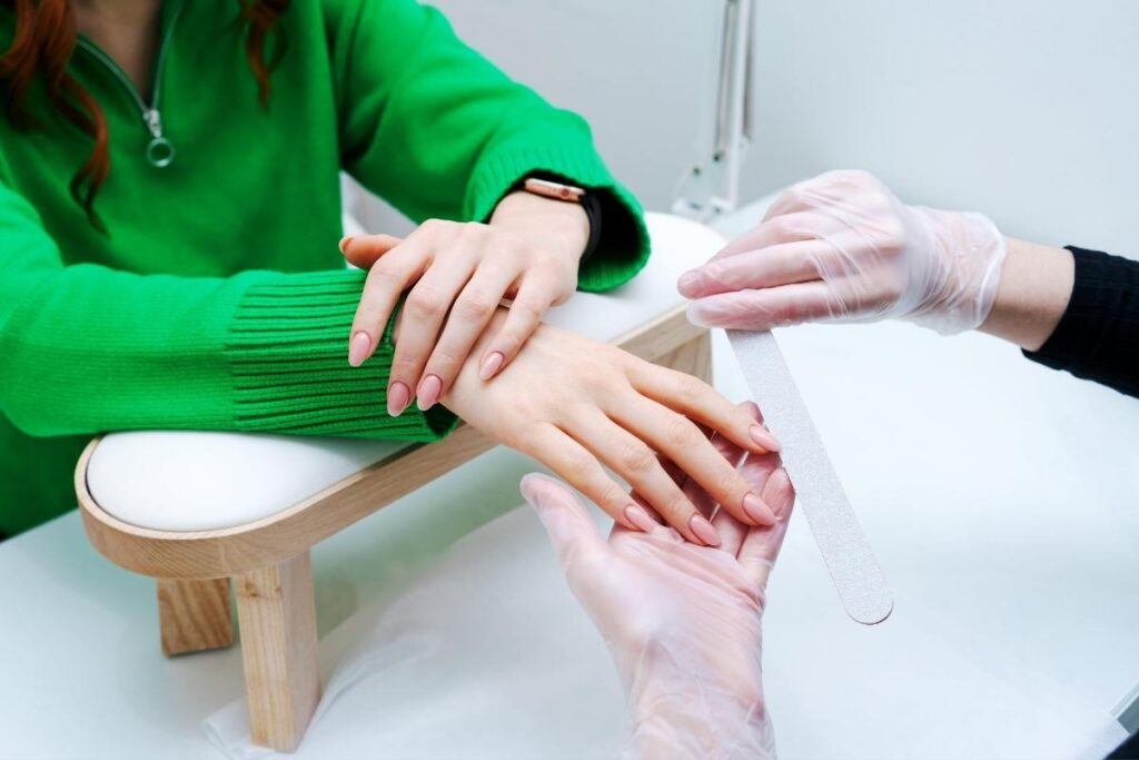 Djevojka radi medicinsku manikuru klijentici